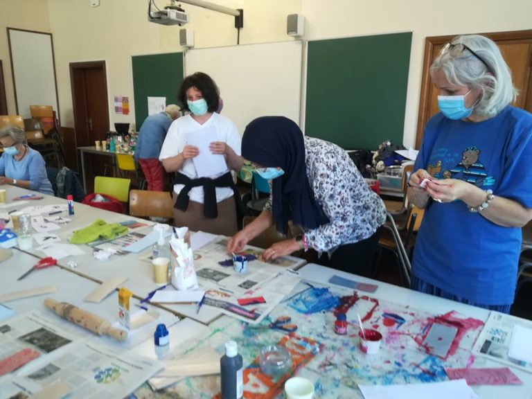 Femmes masquées penchées sur travaux de peinture